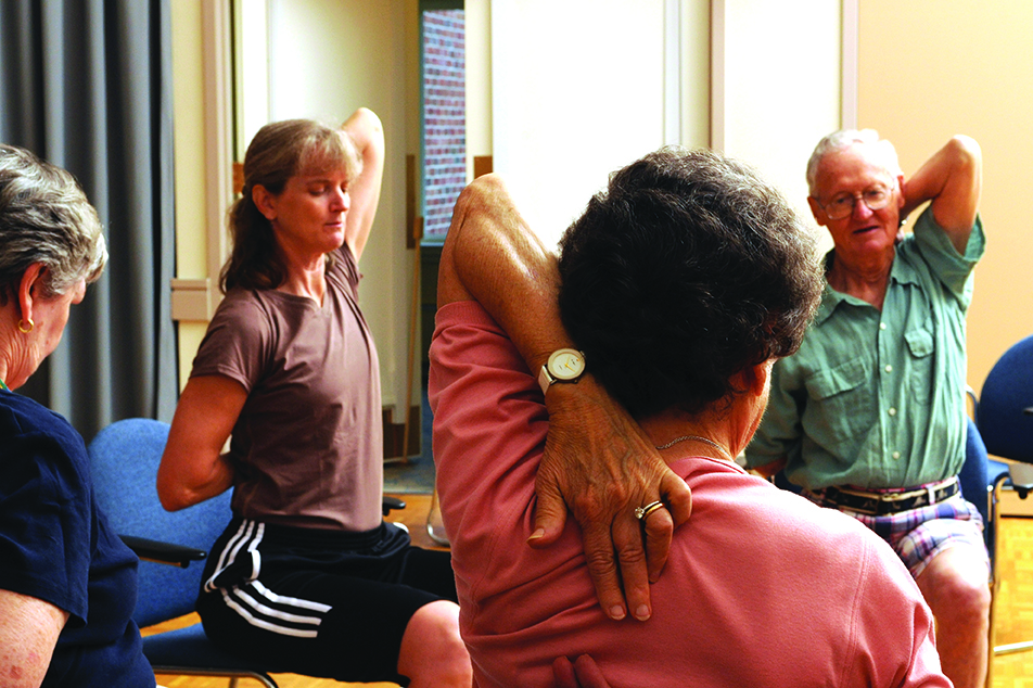 Staff lead residents in chair yoga