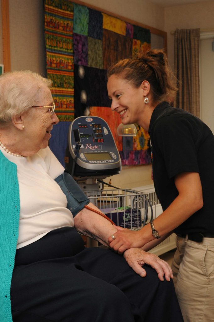 Nurse takes resident's blood pressure
